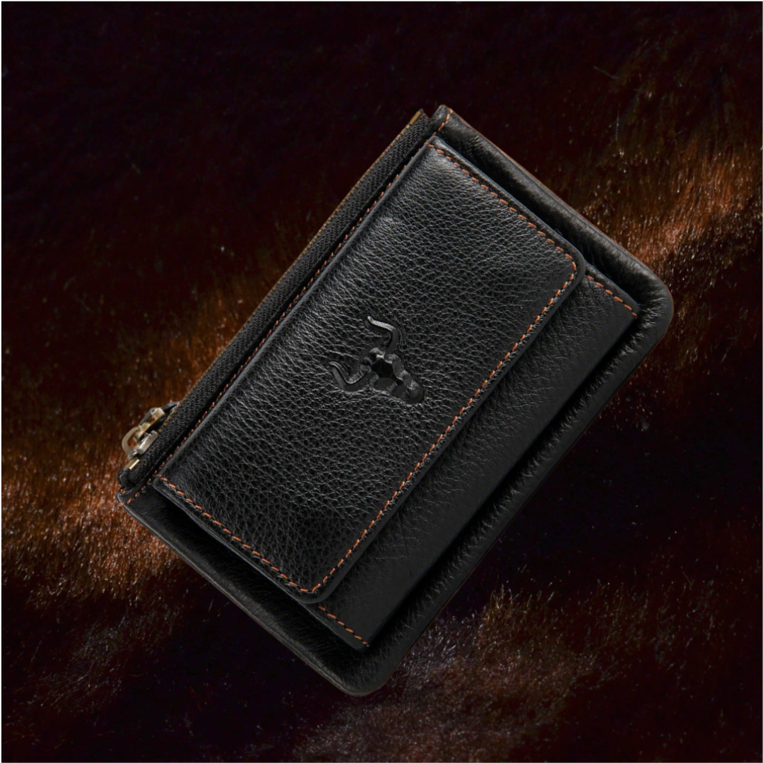 Angled close-up of the MING CLAN black top-grain leather trifold key wallet, featuring rugged orange contrast stitching and the signature embossed bull logo on a dark textured background.