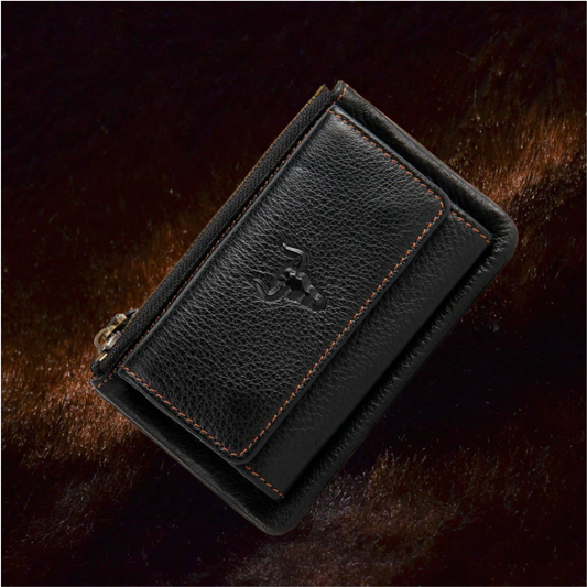 Angled close-up of the MING CLAN black top-grain leather trifold key wallet, featuring rugged orange contrast stitching and the signature embossed bull logo on a dark textured background.