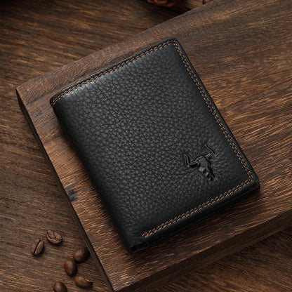 MING CLAN black pebble-grain leather bifold wallet lying flat on a wooden surface, showcasing vintage contrast stitching.